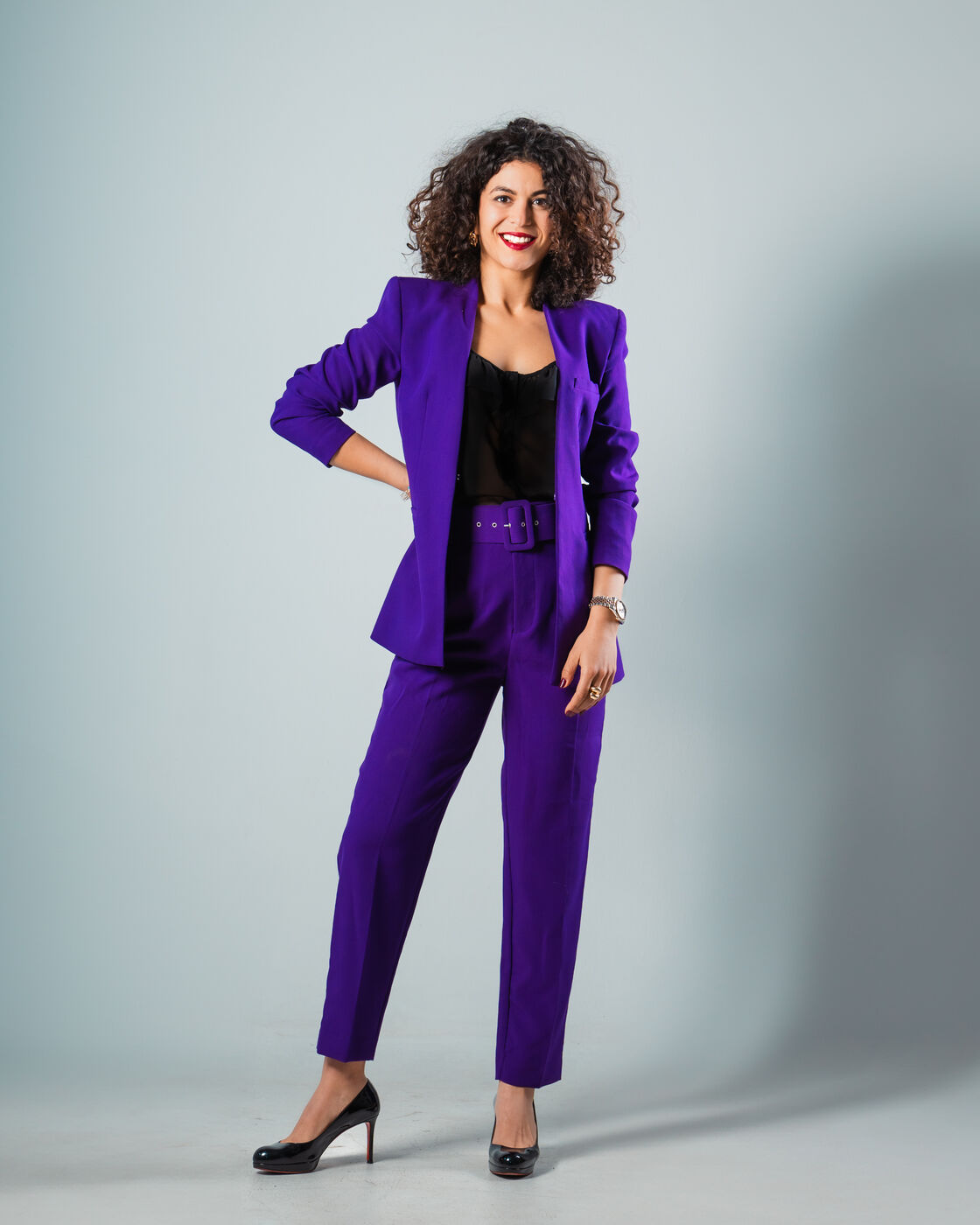 Rita Alaoui in a purple suit, smiling